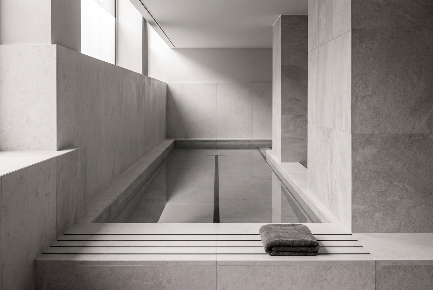 A calm hotel wellness space with a still indoor lap pool